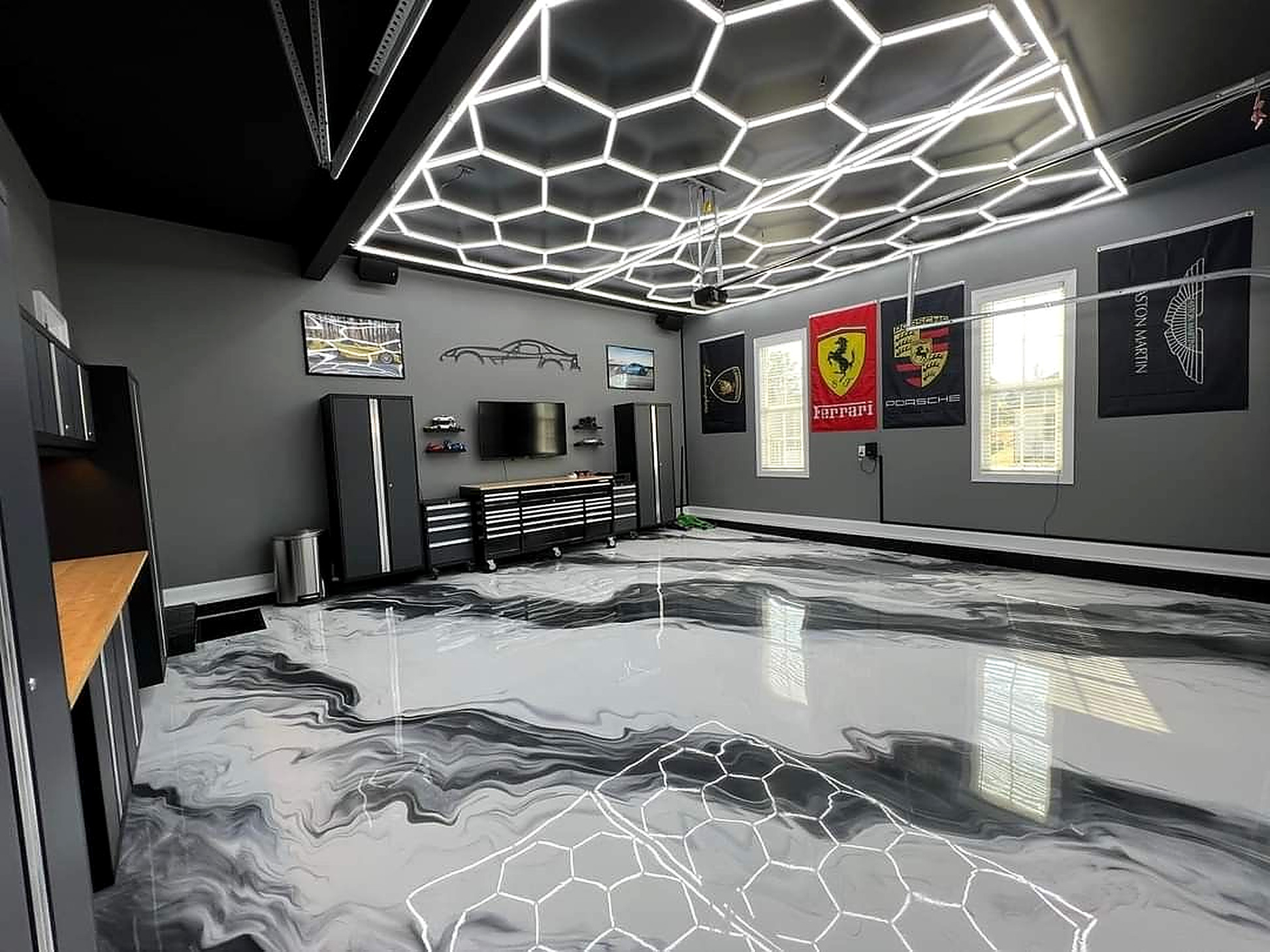 Black and silver metallic epoxy show garage floor with hex lighting in Utah