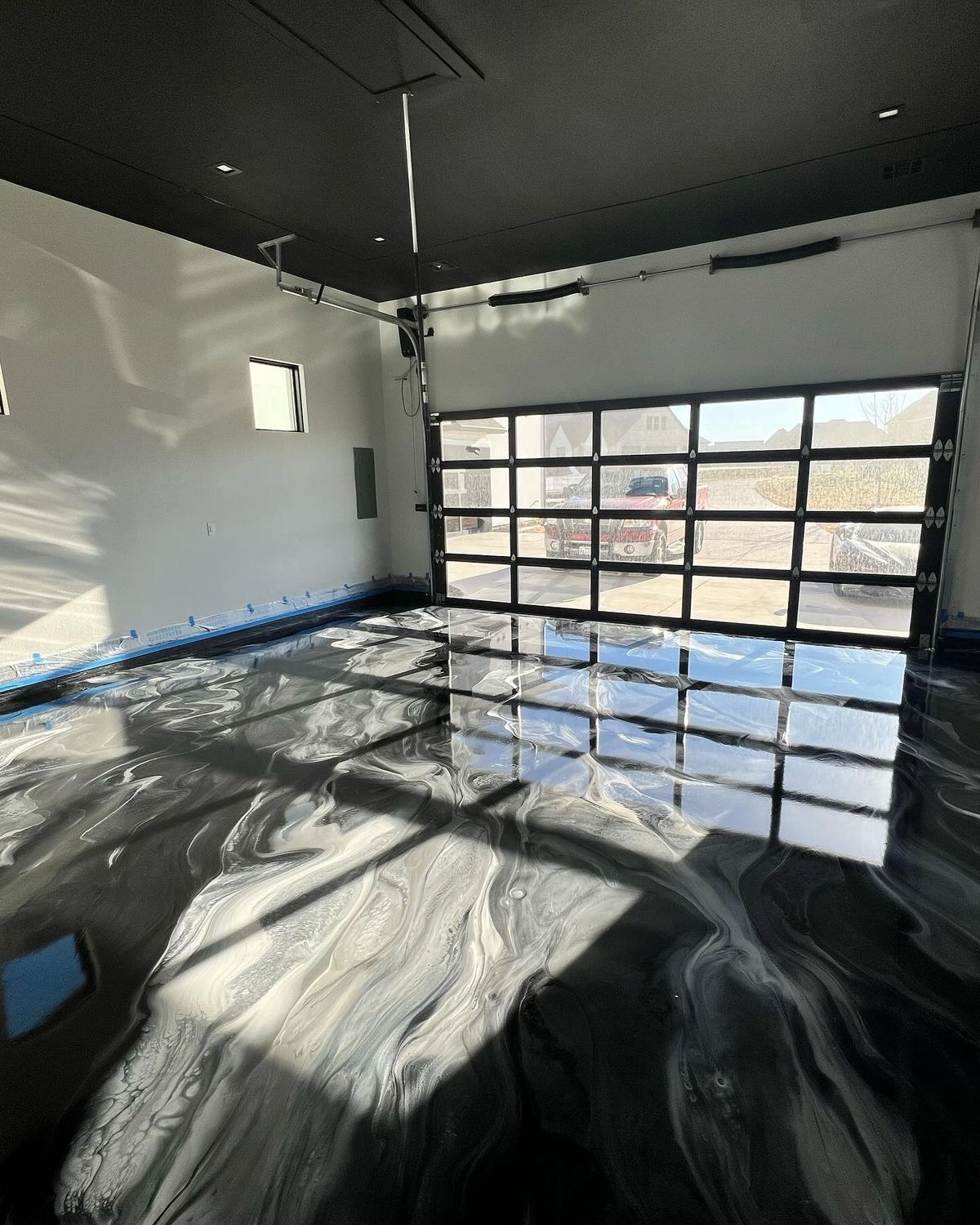 Silver and black metallic floor with glass garage door