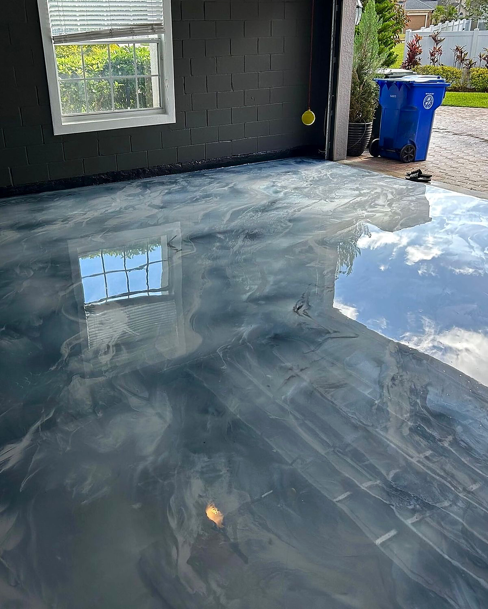 Luxury show garage with black metallic epoxy floor, hex lighting, and a Lamborghini